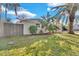 The front yard has a green lawn, tasteful landscaping, and a mature palm tree, enhancing the curb appeal at 6706 Sierra Ter, New Port Richey, FL 34652