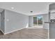 Open-concept living room with modern gray walls, plank flooring, and sliding glass doors to the backyard at 6706 Sierra Ter, New Port Richey, FL 34652