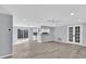 Spacious living room featuring modern flooring, recessed lighting, and access to the kitchen and outdoor space at 6706 Sierra Ter, New Port Richey, FL 34652