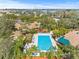 Aerial view of community pool surrounded by tropical landscaping, lounge chairs, and umbrellas at 1007 Lake Avoca Dr, Tarpon Springs, FL 34689