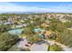Community aerial view featuring tennis courts, swimming pool, clubhouse, and nearby parking at 1007 Lake Avoca Dr, Tarpon Springs, FL 34689