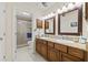 Bathroom features double sinks, granite countertops, tile shower with glass door, and modern fixtures at 1007 Lake Avoca Dr, Tarpon Springs, FL 34689
