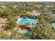 Aerial view of a community pool area with a large pool, seating, palm trees and a recreation center at 1007 Lake Avoca Dr, Tarpon Springs, FL 34689