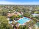 Community pool, jacuzzi, and amenities, surrounded by palm trees, a clubhouse, and tennis courts at 1007 Lake Avoca Dr, Tarpon Springs, FL 34689
