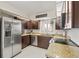 Modern kitchen with stainless steel appliances, granite countertops, dark cabinets, and white tile backsplash at 1007 Lake Avoca Dr, Tarpon Springs, FL 34689