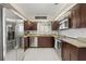 A modern kitchen features stainless steel appliances, granite counters, and dark wood cabinets at 1007 Lake Avoca Dr, Tarpon Springs, FL 34689