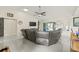 Open-concept living room with a large sectional sofa, tile flooring, and sliding glass doors at 1007 Lake Avoca Dr, Tarpon Springs, FL 34689