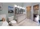 Well-lit bathroom featuring dual vanities, a glass-enclosed shower, and a bathtub at 102 Brent Cir, Oldsmar, FL 34677