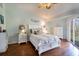 Bedroom features hardwood floors, a white bed frame, and a sliding glass door at 102 Brent Cir, Oldsmar, FL 34677