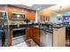 Modern kitchen boasts stainless appliances, granite counters, and bar seating area at 102 Brent Cir, Oldsmar, FL 34677
