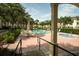 Community pool and hot tub with lounge chairs and shaded seating areas at 102 Brent Cir, Oldsmar, FL 34677