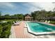Community pool and hot tub with lounge chairs and shaded seating areas at 102 Brent Cir, Oldsmar, FL 34677