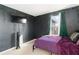 This bedroom offers dark walls, greenery accents, and natural light from the windows, crafting a unique retreat at 11804 Bluegrass Field Ct, Riverview, FL 33579