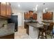 Well-lit kitchen featuring wood cabinetry, granite countertops, stainless appliances, and a central island with bar seating at 11804 Bluegrass Field Ct, Riverview, FL 33579