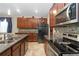 Charming kitchen featuring granite countertops, stainless appliances, wood cabinetry, and a mosaic backsplash at 11804 Bluegrass Field Ct, Riverview, FL 33579
