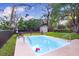 Backyard view of the in-ground pool, shed, and lawn area, great for relaxing and entertaining at 15808 Sea Pines Dr, Hudson, FL 34667