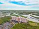 Aerial view of condo building situated on lush landscaping near the river at 4516 Seagull Dr # 303, New Port Richey, FL 34652