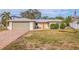 Charming single-story home featuring a vibrant orange front door and well-maintained landscaping at 10100 Paradise Blvd, Treasure Island, FL 33706