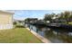 A serene canal view from the backyard, surrounded by lush greenery and featuring a dock at 114 W Saint Johns Way, Apollo Beach, FL 33572