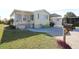 Charming manufactured home featuring colorful Adirondack chairs and lush lawn at 114 W Saint Johns Way, Apollo Beach, FL 33572