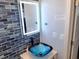Bathroom featuring a modern sink, backlit mirror, and blue tile accent wall at 16333 Gulf Blvd # 105, St Petersburg, FL 33708