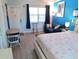 Cozy bedroom featuring bright blue walls, wood-look floors, and starfish-themed bedding at 16333 Gulf Blvd # 105, St Petersburg, FL 33708