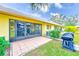 Exterior view of yellow home featuring a screened lanai, patio, well-kept lawn, and mature trees at 2546 Oakleaf Ln # 35D, Clearwater, FL 33763