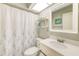 Cozy bathroom with framed mirror, decorative shelves, shower with curtain and white sink at 2546 Oakleaf Ln # 35D, Clearwater, FL 33763