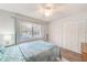 Relaxing bedroom with wood floors, large window, closet, ceiling fan and comfortable bed with blue comforter at 2546 Oakleaf Ln # 35D, Clearwater, FL 33763