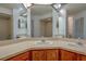 Bathroom featuring double sinks, a large mirror, and wood cabinets at 2567 Bentley Dr, Palm Harbor, FL 34684