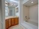 Well-lit bathroom featuring double sinks, a large mirror, and a shower-tub combo at 2567 Bentley Dr, Palm Harbor, FL 34684