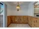 Cozy dining area featuring wood paneling and a classic hanging light fixture at 2567 Bentley Dr, Palm Harbor, FL 34684