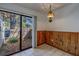 Dining area with wood paneling, a retro light fixture, and sliding glass doors to a patio at 2567 Bentley Dr, Palm Harbor, FL 34684