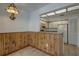 Dining area with wood paneling, a retro light fixture, and kitchen access at 2567 Bentley Dr, Palm Harbor, FL 34684
