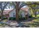 Charming home exterior with mature trees and a well-manicured lawn at 2567 Bentley Dr, Palm Harbor, FL 34684