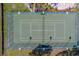 Overhead drone shot of a tennis court with green surface, white lines and net at 2567 Bentley Dr, Palm Harbor, FL 34684