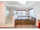 Luxurious bathroom with a glass shower, soaking tub, elegant finishes, and abundant natural light at 2902 N Shoreview Pl, Tampa, FL 33602