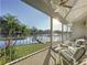 Covered patio with outdoor seating overlooking a lake, palm trees, and a private dock at 2902 N Shoreview Pl, Tampa, FL 33602