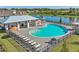 Aerial view of the community pool, cabana, lounge chairs, and lake in the background at 4010 112Th E St, Palmetto, FL 34221