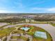 A high angle view of a community center featuring a pool, playground, tennis courts, and clubhouse at 5045 Ivory Stone Dr, Wimauma, FL 33598
