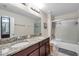 Bathroom boasts double sinks with granite countertop, a shower-tub combination and tile floors at 5045 Ivory Stone Dr, Wimauma, FL 33598