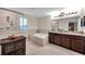 Bright bathroom features granite countertops, double sinks, a soaking tub, and a glass-enclosed shower at 5045 Ivory Stone Dr, Wimauma, FL 33598
