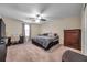 Bedroom features ceiling fan, a window, a large dresser, and space for a desk and storage at 5045 Ivory Stone Dr, Wimauma, FL 33598