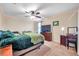 Bedroom features ceiling fan, dresser storage, desk space and neutral carpet at 5045 Ivory Stone Dr, Wimauma, FL 33598