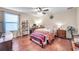 Bright bedroom featuring a ceiling fan, wood floors, a window and space for a desk and storage at 5045 Ivory Stone Dr, Wimauma, FL 33598