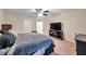 This bedroom includes a ceiling fan, closet, and television atop a wooden media console at 5045 Ivory Stone Dr, Wimauma, FL 33598