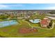 Aerial view showcases the community pool, tennis courts, playground, and surrounding neighborhood at 5045 Ivory Stone Dr, Wimauma, FL 33598