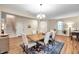 Dining room with wood floors features a chandelier and a large window with curtains and nearby staircase at 5045 Ivory Stone Dr, Wimauma, FL 33598
