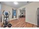 A look into the living room from the exercise room, which has wood floors and an elliptical trainer at 5045 Ivory Stone Dr, Wimauma, FL 33598