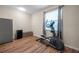 Bright exercise room with wood floors, an elliptical, stainless steel refrigerator, and a window letting in natural light at 5045 Ivory Stone Dr, Wimauma, FL 33598
